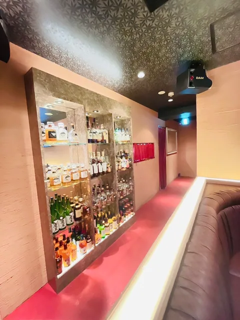 ボトル棚に沿うローズ色の店内通路